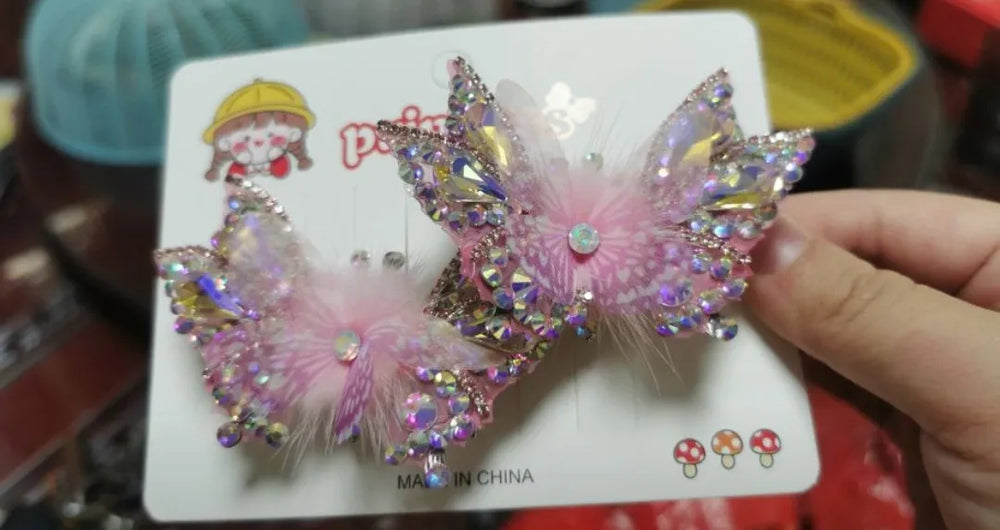 Detailed view of butterfly hair clip showing crystal decoration and smooth electroplated finish