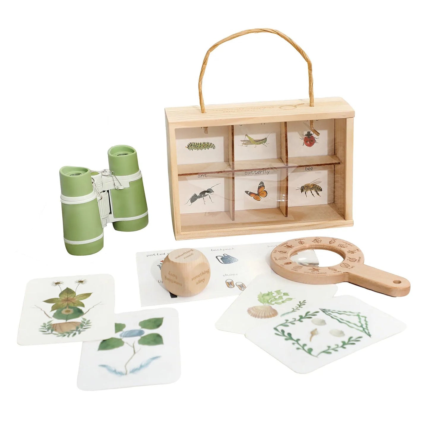 Children's nature exploration set with wooden box, binoculars, magnifying glass, and cards on a white background