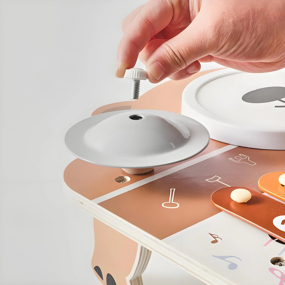 Toddler tapping drum on natural wood 6-in-1 music toy