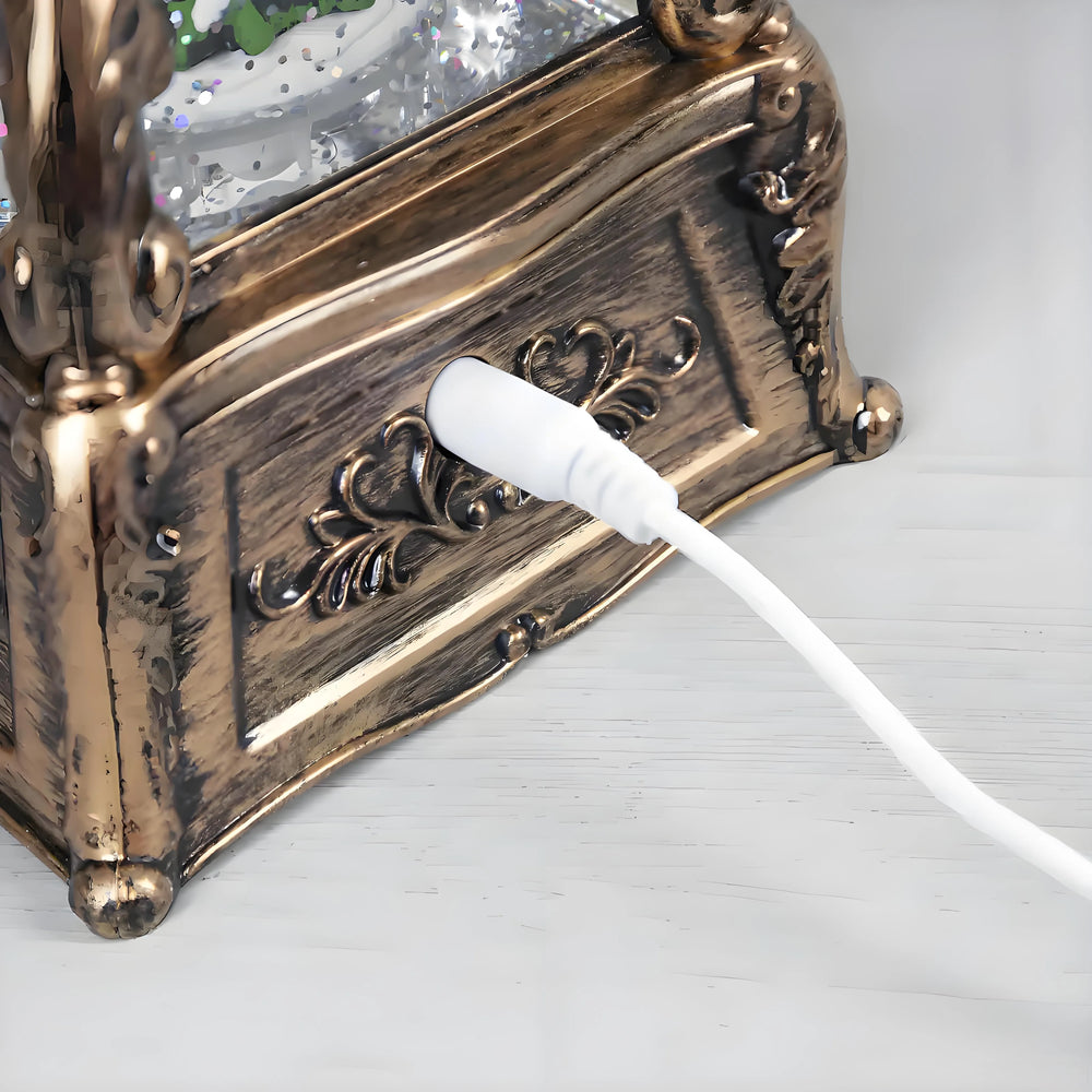 Antique bronze phonograph style snow globe lantern displayed on wooden shelf for holiday décor.