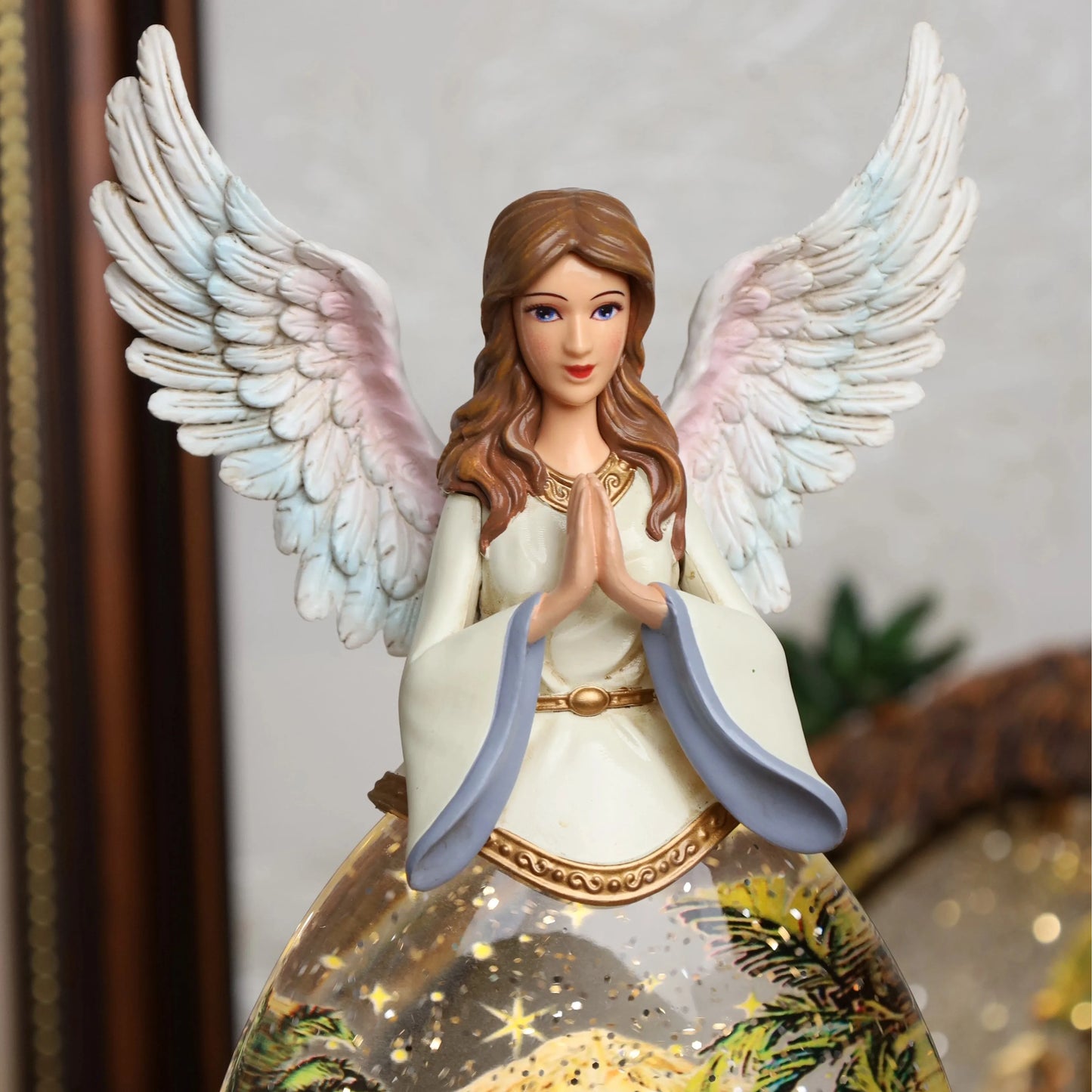 Close-up of nativity snow globe showing angel details and snowfall effect