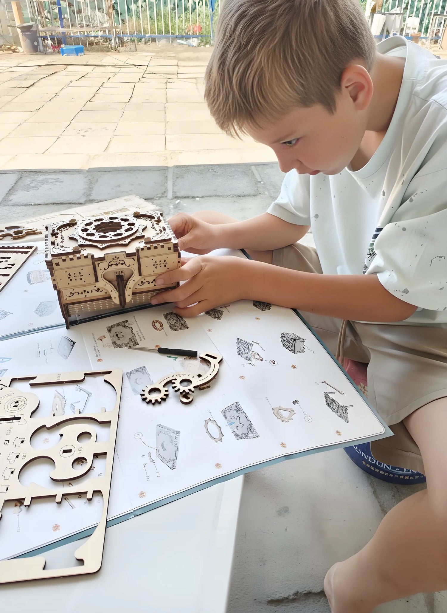 Child assembling a wooden puzzle on a table outdoors