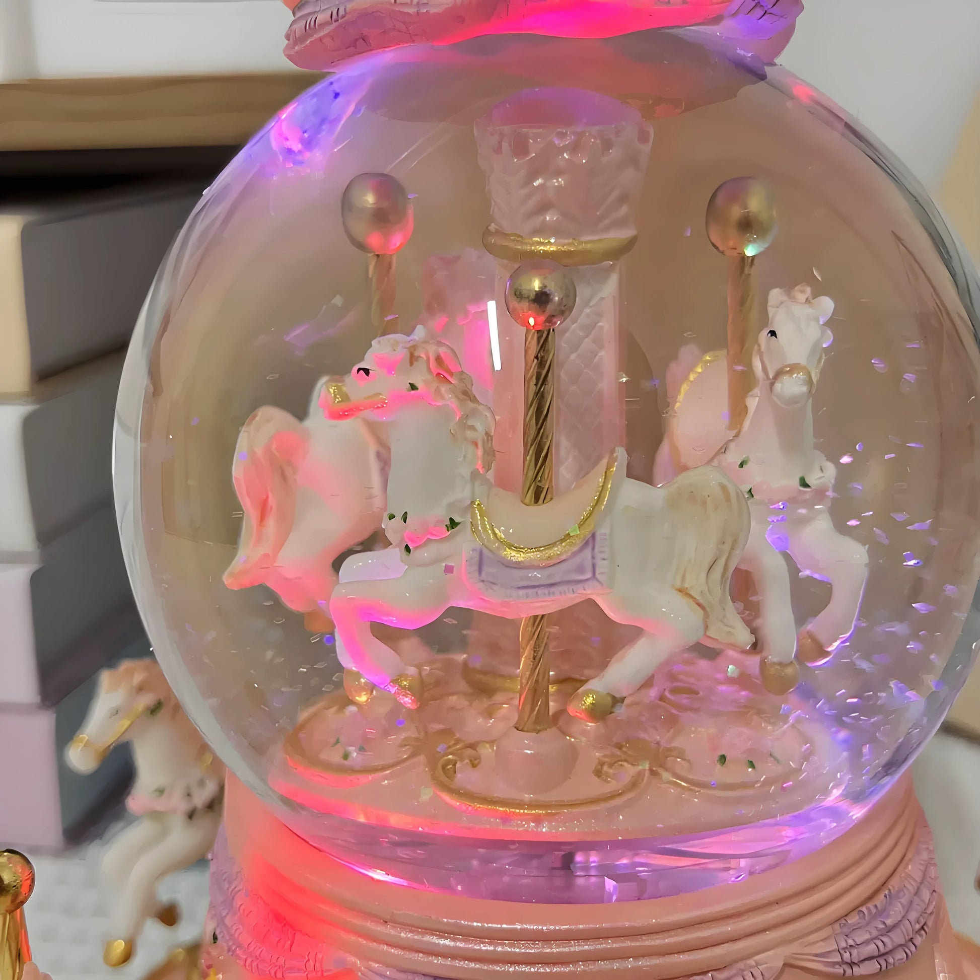 Decorative snow globe with carousel horses and colorful lights