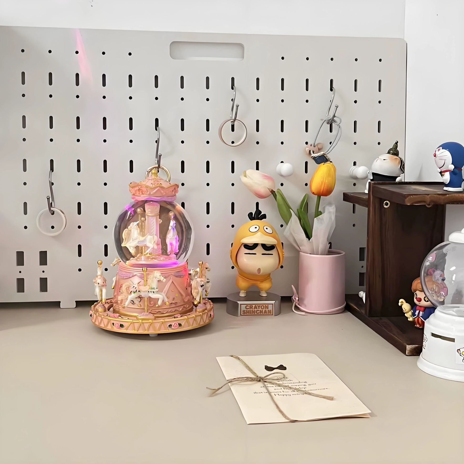 Decorative items on a desk including a snow globe, small figurines, and a card.