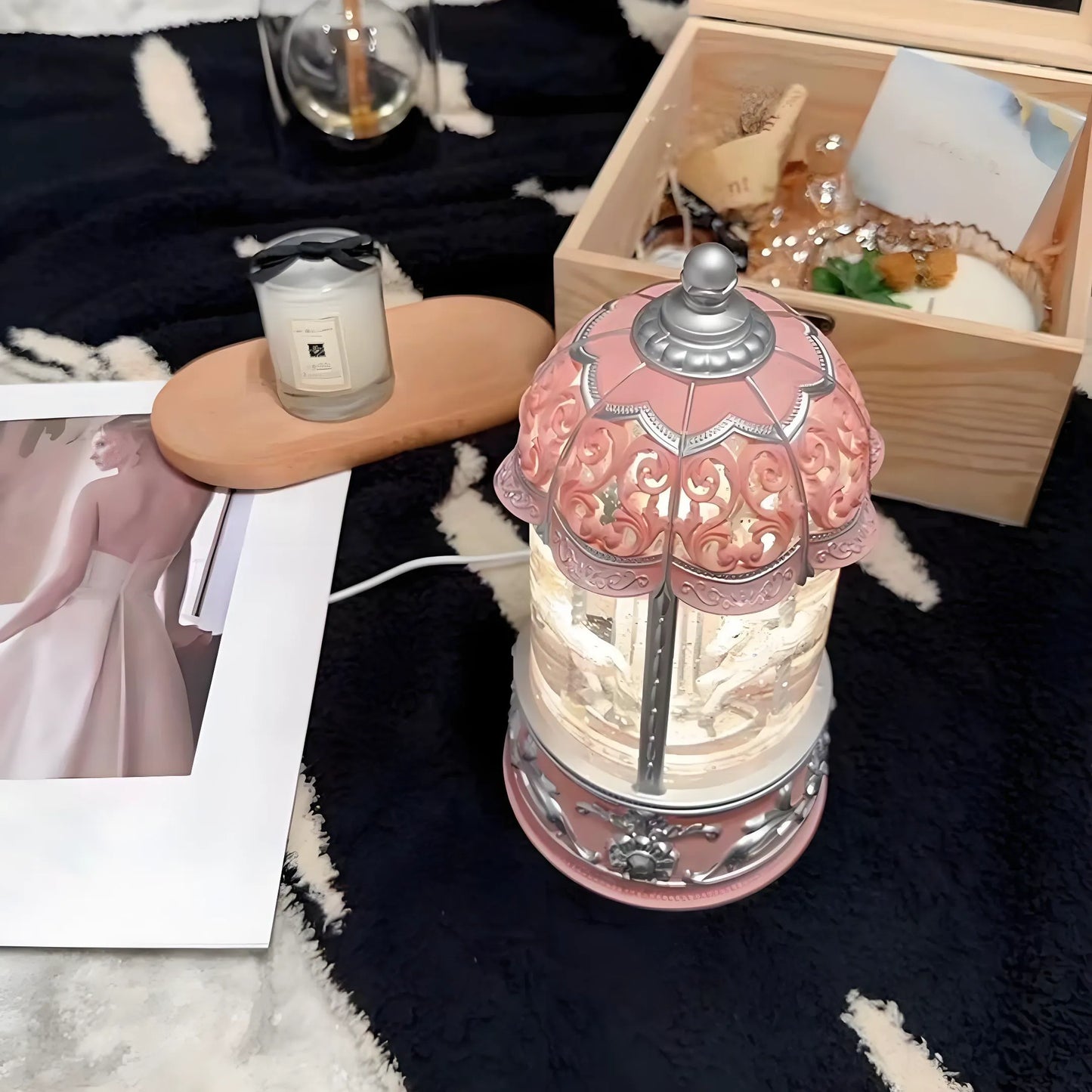 Close-up of pink carousel snow globe showing realistic snow and spinning horses