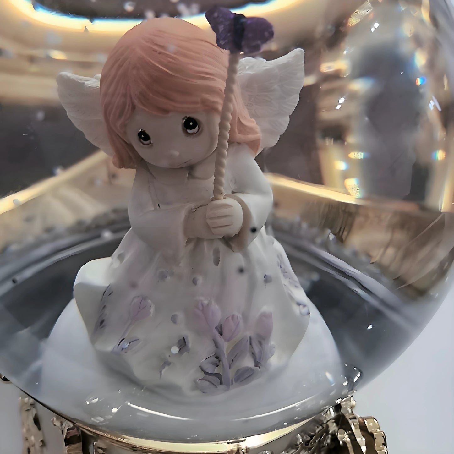 Decorative angel figurine with pink hair and white dress inside a glass display case.