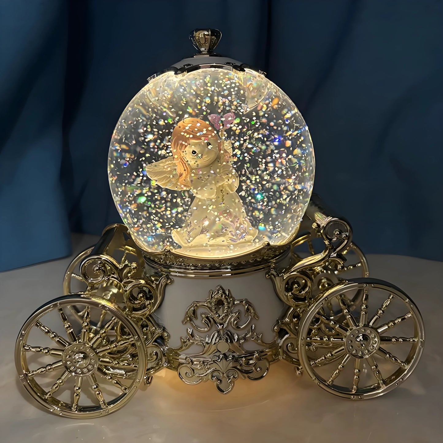 Musical snow globe pumpkin carriage with rotating wheels shown from side angle