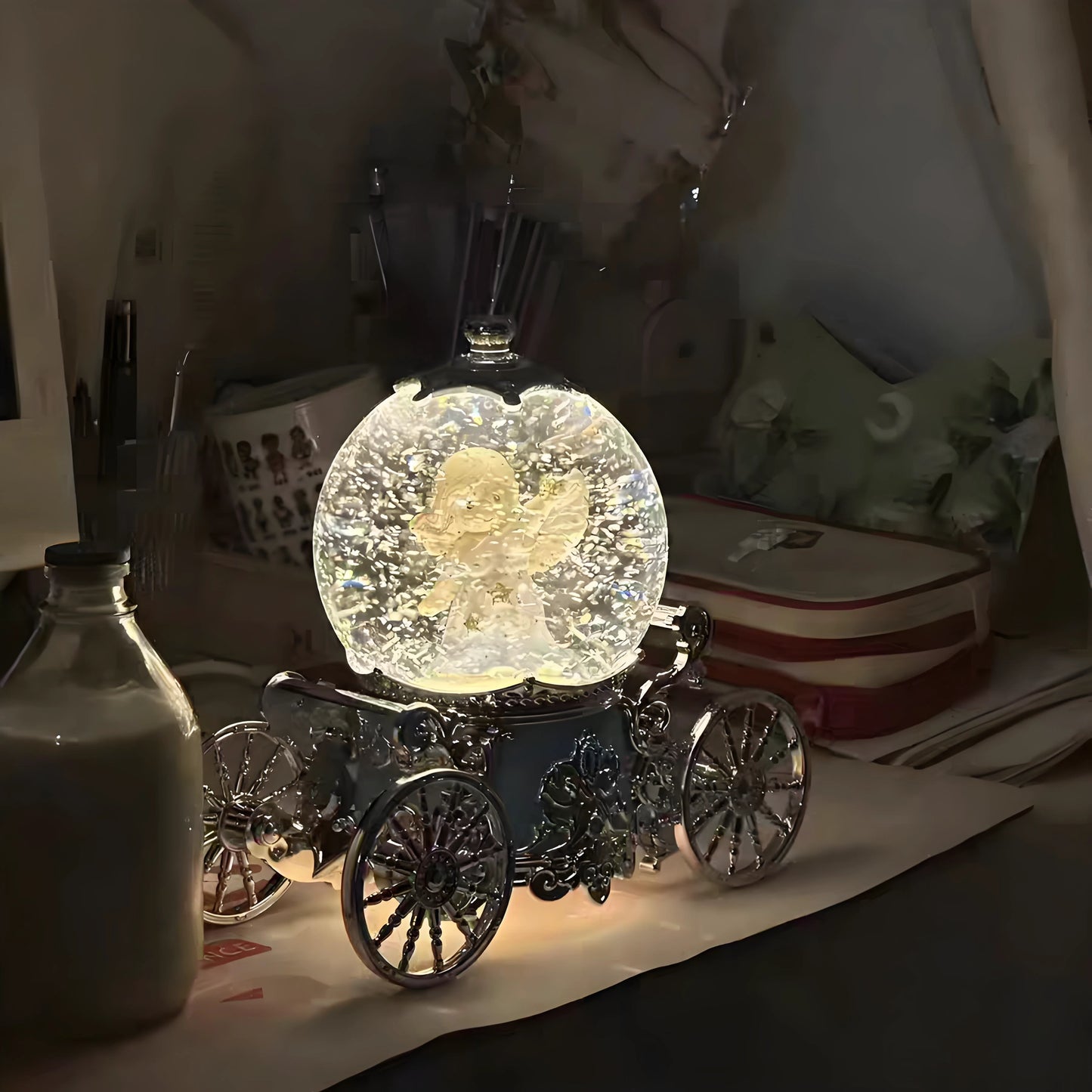 Decorative crystal ball with a butterfly inside on a carriage-like stand, placed on a surface.