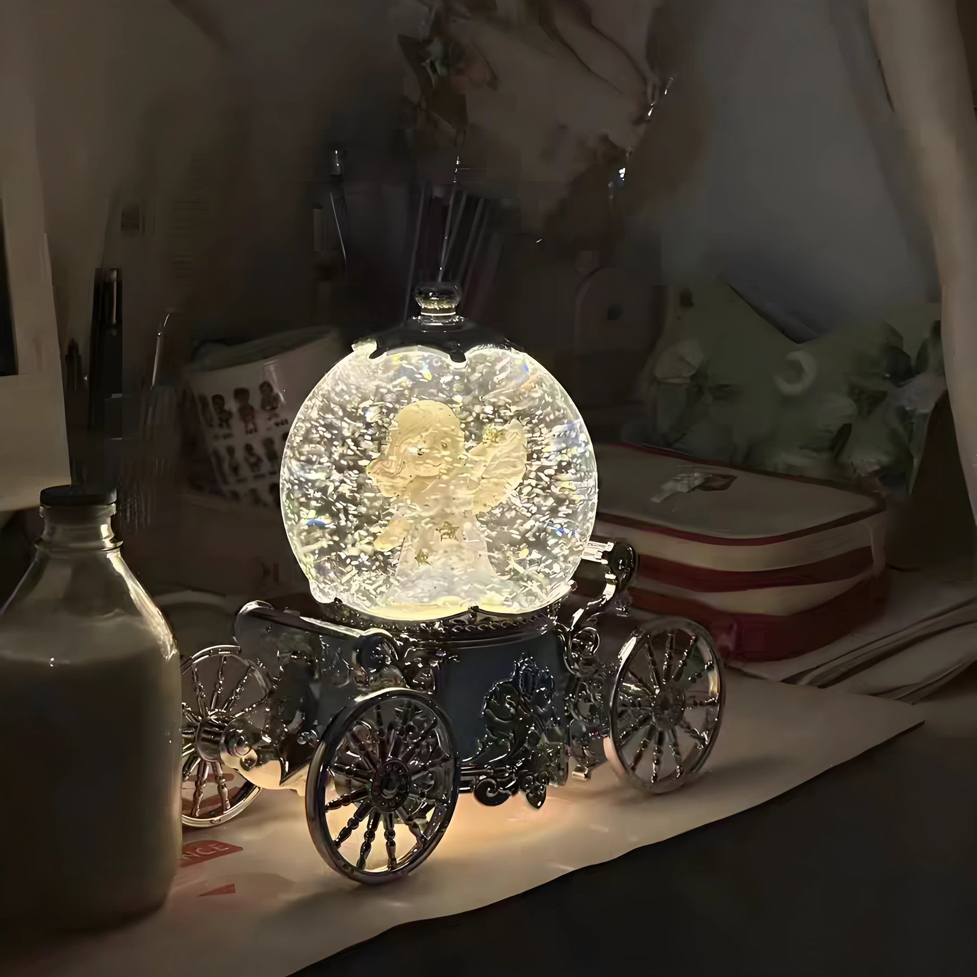 Decorative crystal ball with a butterfly inside on a carriage-like stand, placed on a surface.