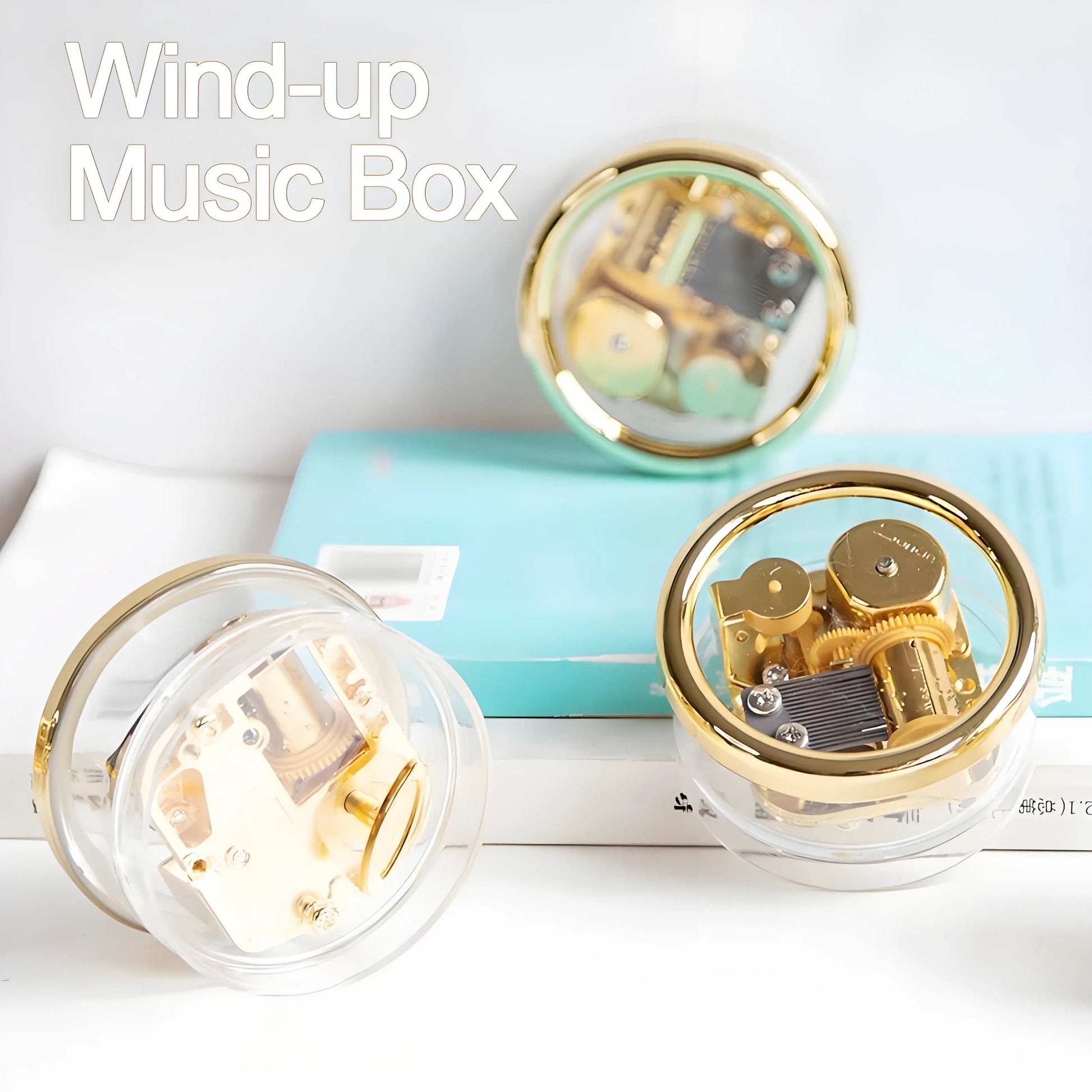 Small retro wind-up music box, transparent case revealing gears and golden metal movement