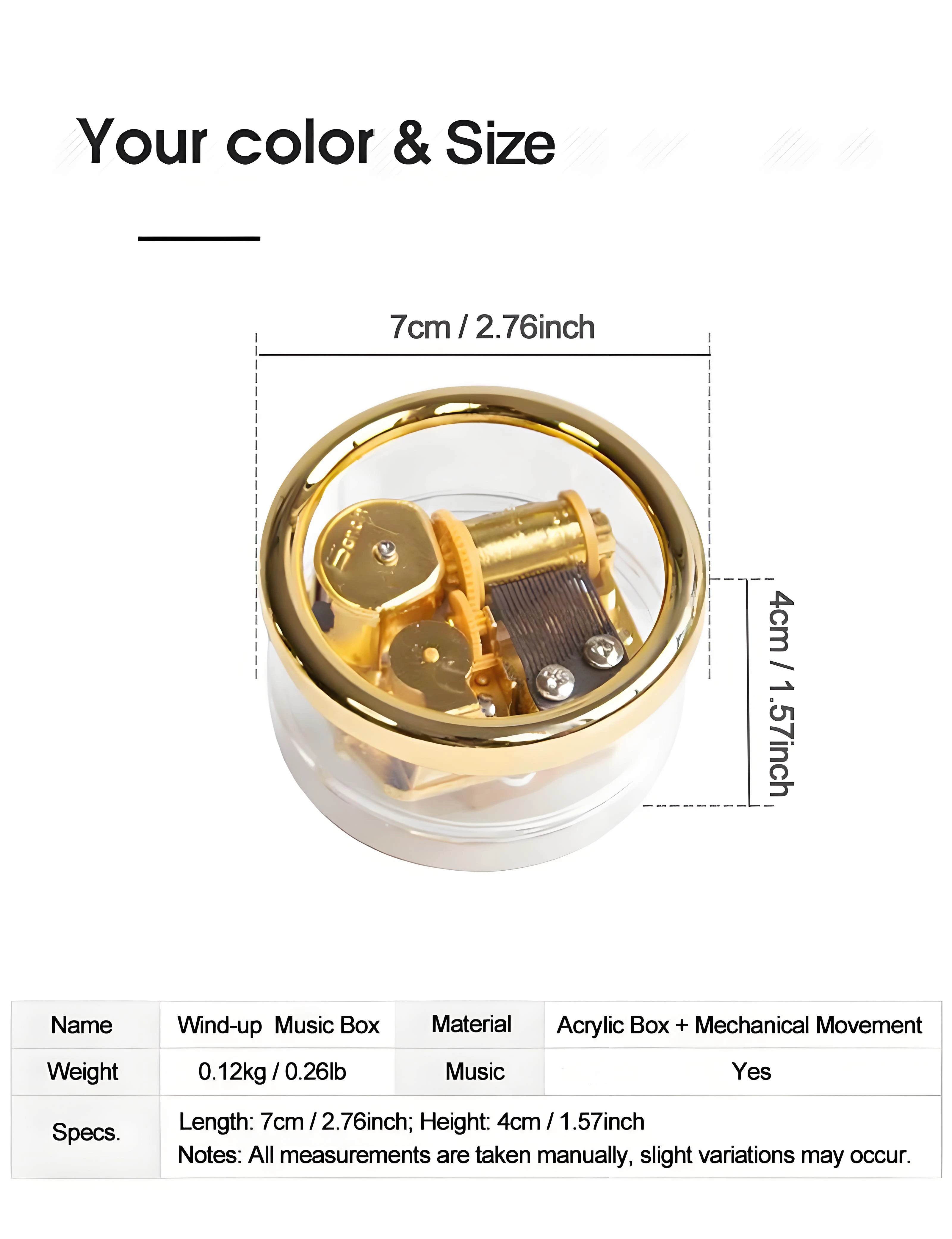 Small retro wind-up music box, transparent case revealing gears and golden metal movement