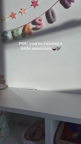 Toddler enjoying musical playtime at home with a wooden percussion set